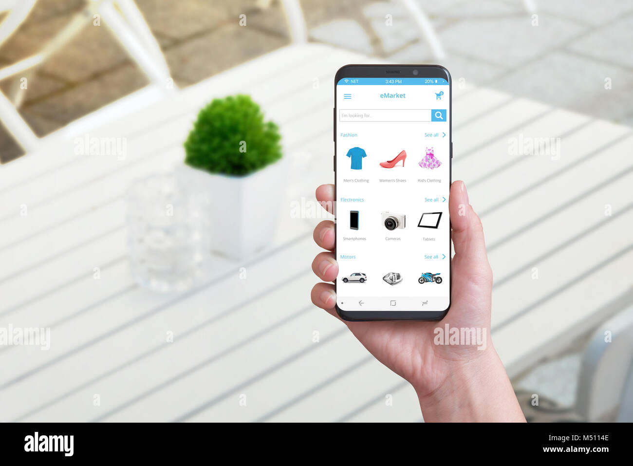 Online Shopping App auf smart phone mit runden Kanten. Coffee Shop im Hintergrund. Stockfoto