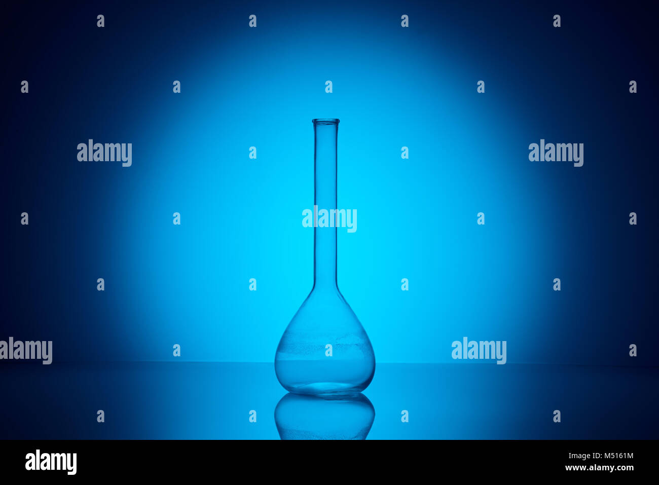 Eine transparente Glaskolben auf reflektierenden Tabelle im Labor auf Blau Stockfoto