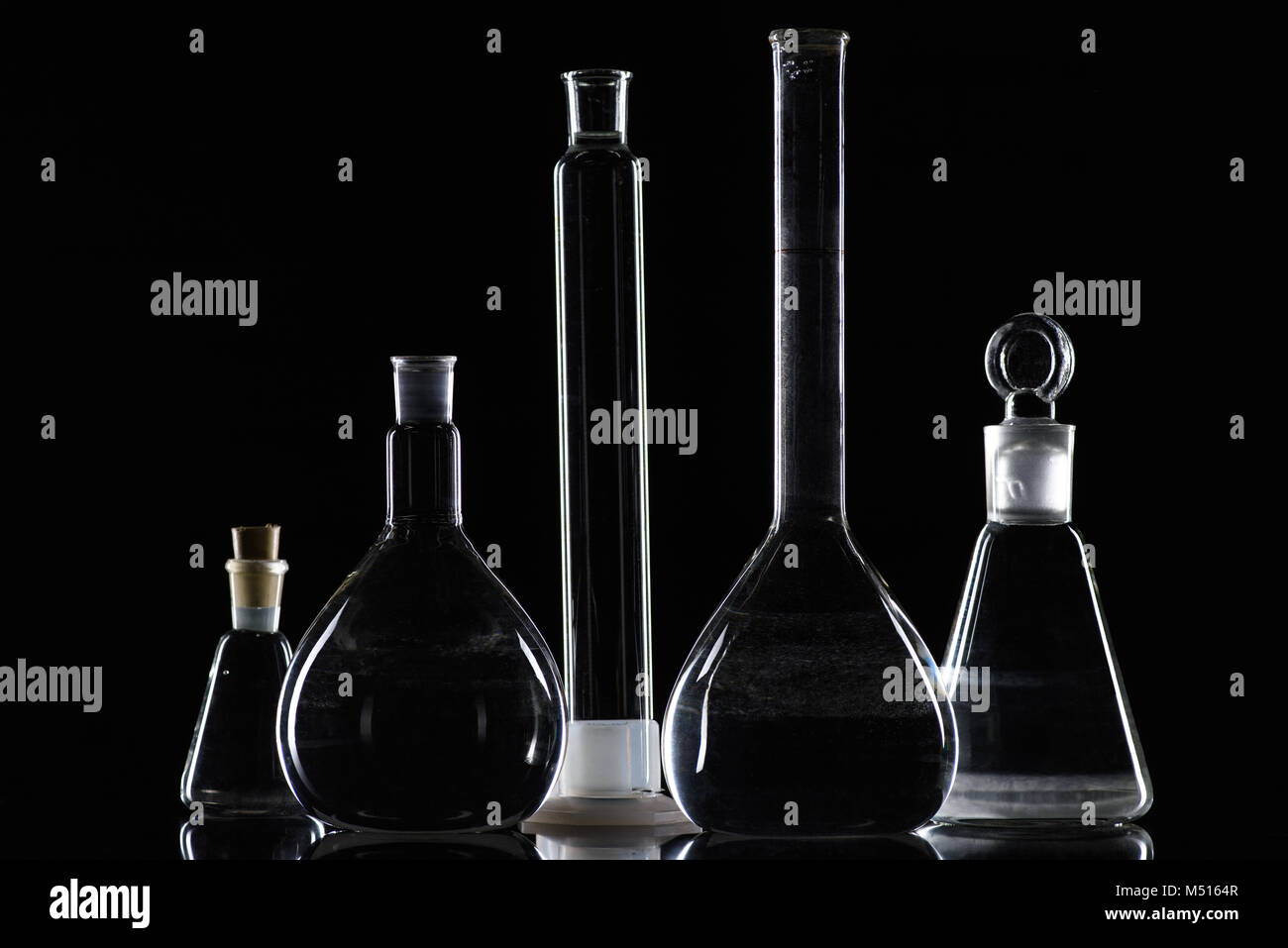 Transparente Glaskolben mit Substanz im Labor auf Schwarz Stockfoto