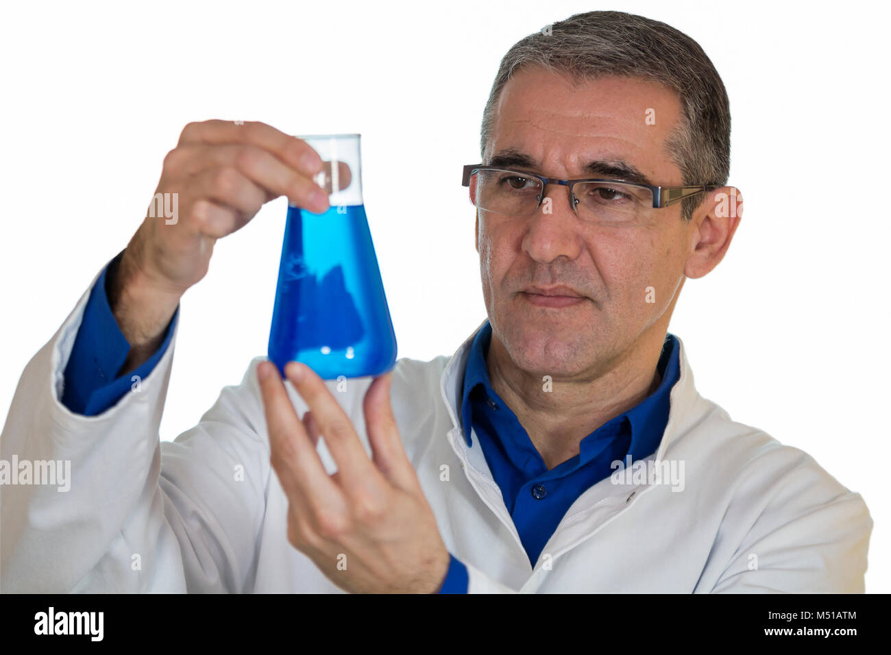 Chemiker, die bis Becher blau Chemische auf weißen Hintergrund. Im mittleren Alter Wissenschaftler überprüfen ein Becherglas mit blauer Flüssigkeit. Stockfoto
