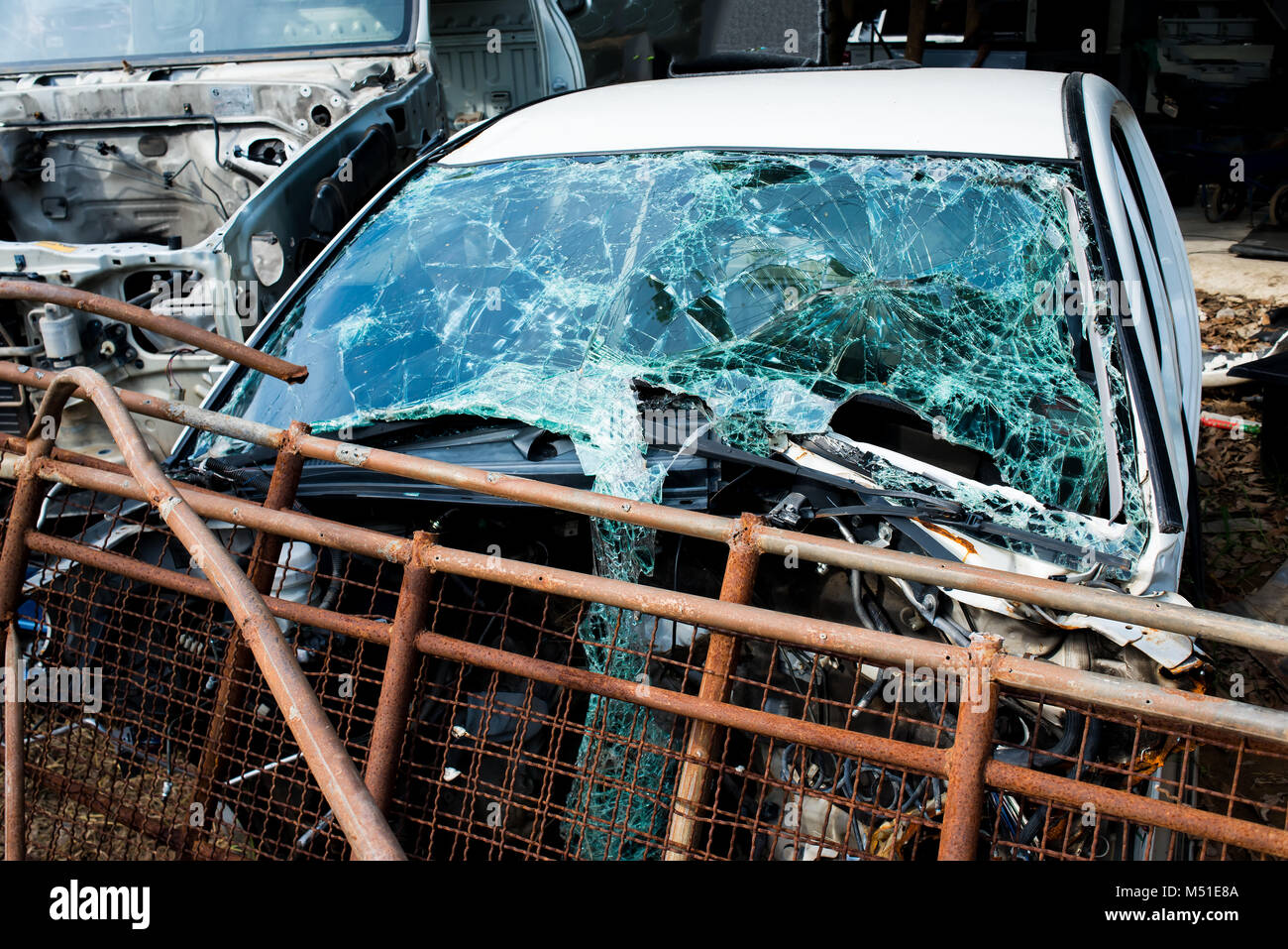 Die crash Unfall Auto whit gebrochene Frontscheibe Spiegel an den Papierkorb garage Foto mit niedriger Beleuchtung im Freien. Stockfoto