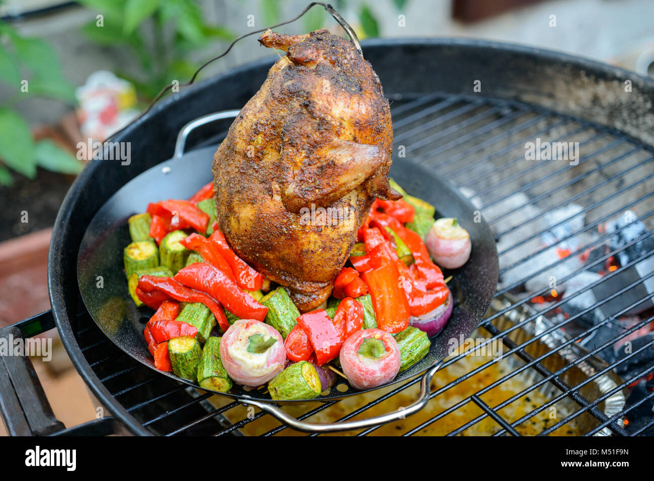 Grillen eine Bierdose Huhn in einem Grill, mit Paprikapulver einreiben und  Temperaturfühler, Gemüse in der Pfanne Stockfotografie - Alamy