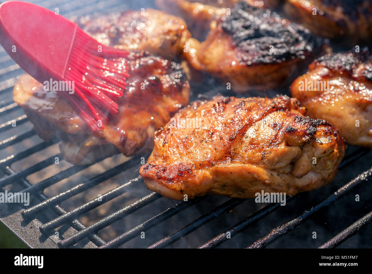 Gegrillte Hähnchenschenkel auf dem brennenden grill Stockfoto