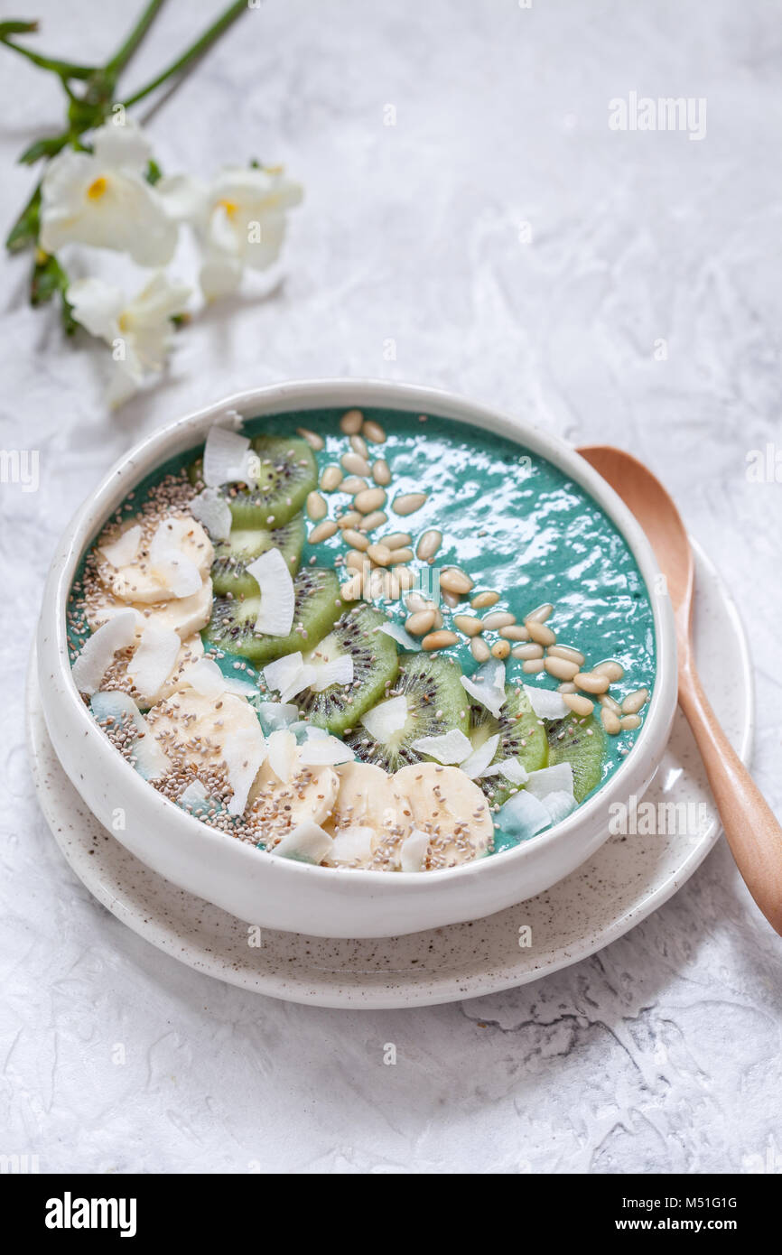 Frühstück spirulina Coconut smoothie Schüssel gekrönt mit Kokosraspeln und Beeren Stockfoto