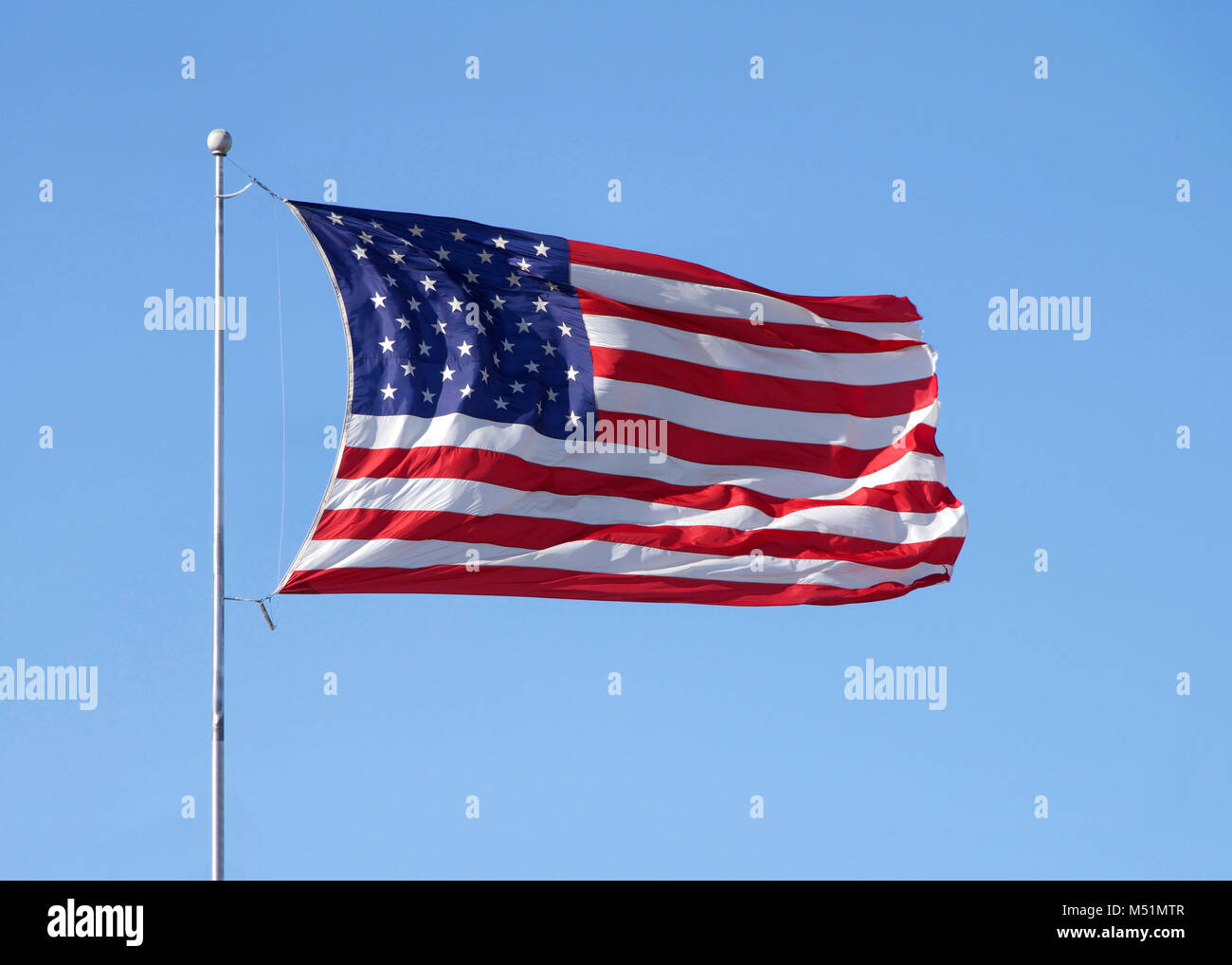 Amerikanische Flagge schwenkten in starkem Wind, blauer Himmel. Stockfoto