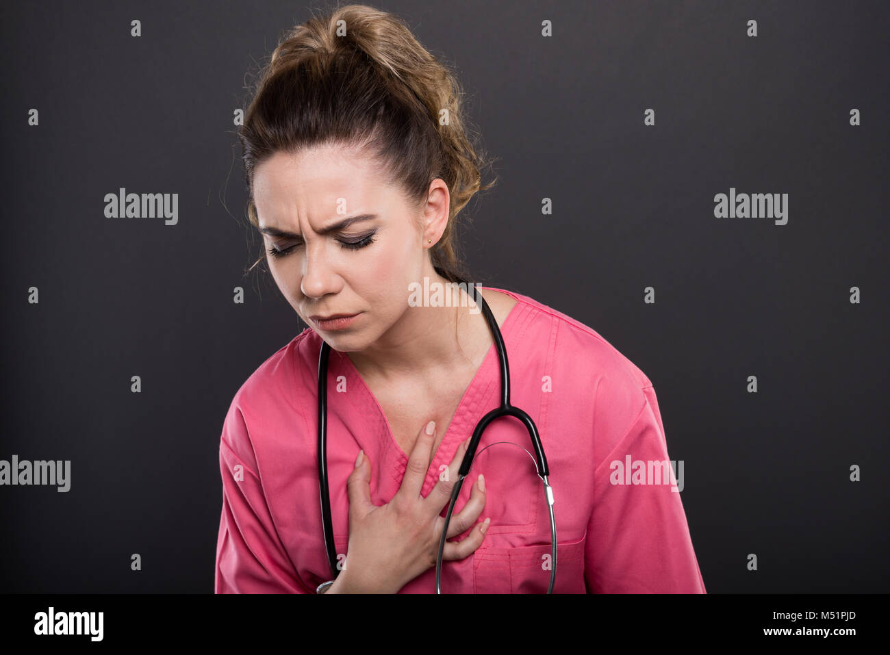 Portrait von Frau Doktor holding Brust wie Hitze Angriff auf schwarzen Hintergrund mit copypsace Werbefläche Stockfoto