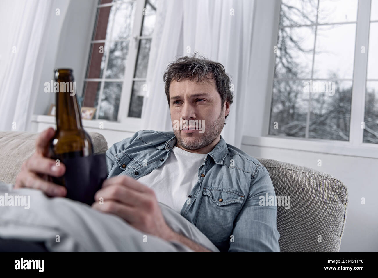 Junge Person Alkoholkrank und Suchen auf der Flasche Stockfoto