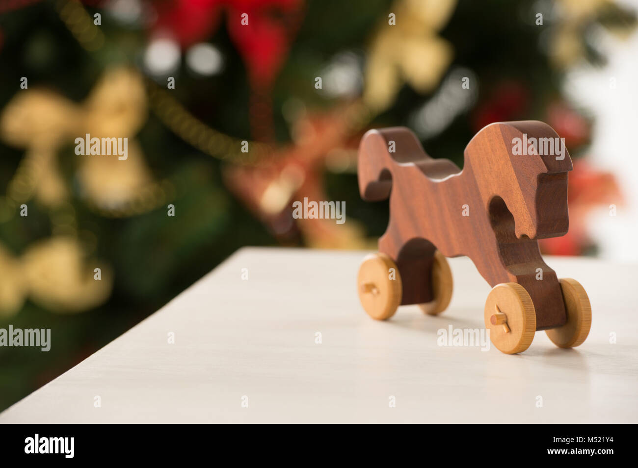 Vintage Wooden Horse auf Santa's Arbeitstisch, Weihnachtsbaum auf Hintergrund Stockfoto