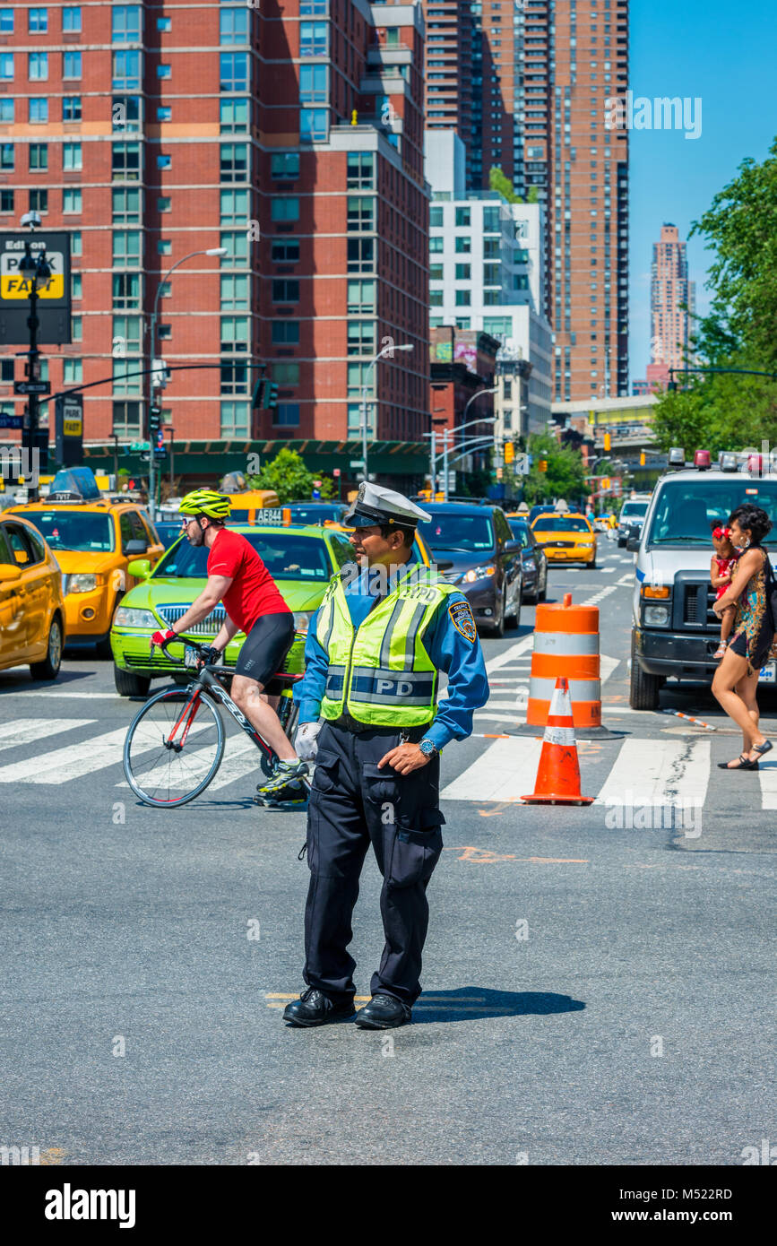 Polizeioffizier Umgang mit Verkehr in einer Straße in Manhattan, New York City, USA Stockfoto