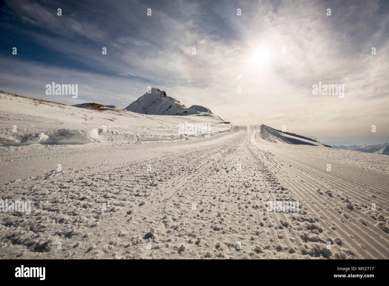 Loipe im Schnee als abstrakten Hintergrund, helle Wintersonne am strahlend blauen Himmel Stockfoto