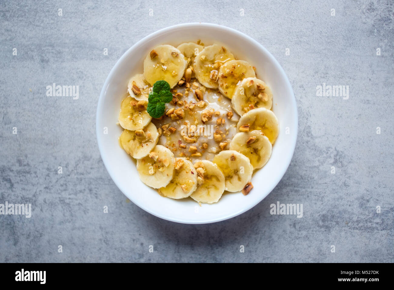 Haferflocken mit Banane, Nüssen und Honig Stockfoto