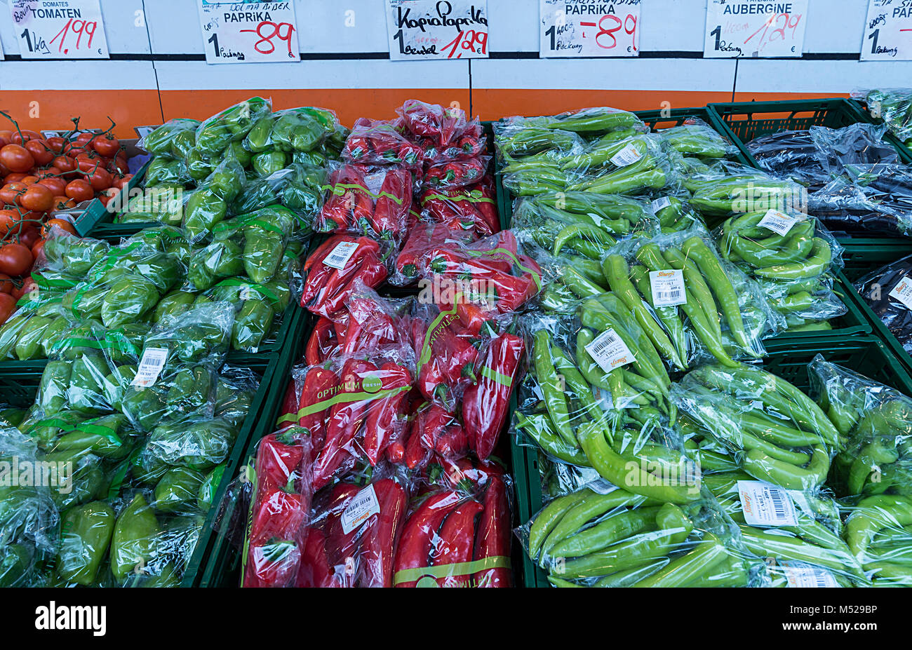 Verschiedene Arten von Paprika in Kunststofffolie mit einem Stand für Gemüse, Bayern, Deutschland Stockfoto