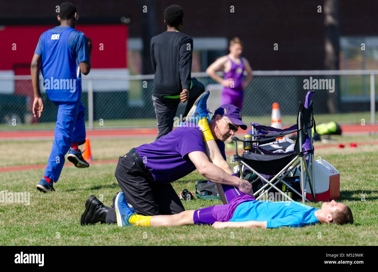 Medic behandelt verletzten Athleten. auf Schiene und Feld in Albany, NY treffen Stockfoto