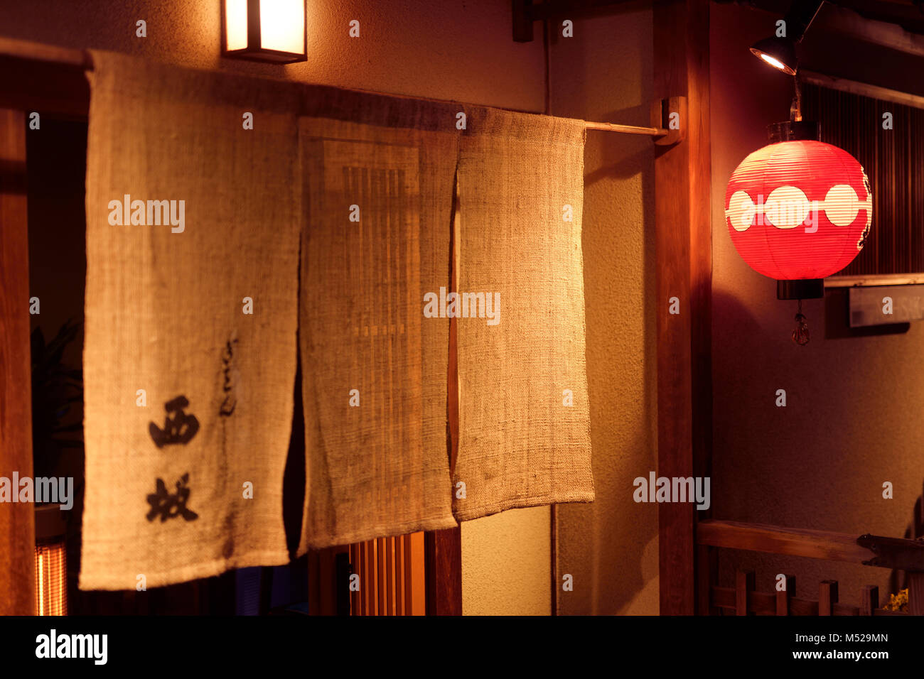 Nishizaka traditionelles japanisches Restaurant in Kyoto Gion, Eingangstür  mit einem Noren Vorhang und eine rote Laterne in der Nacht. Hanamikoji Dori  Straße in Gio Stockfotografie - Alamy