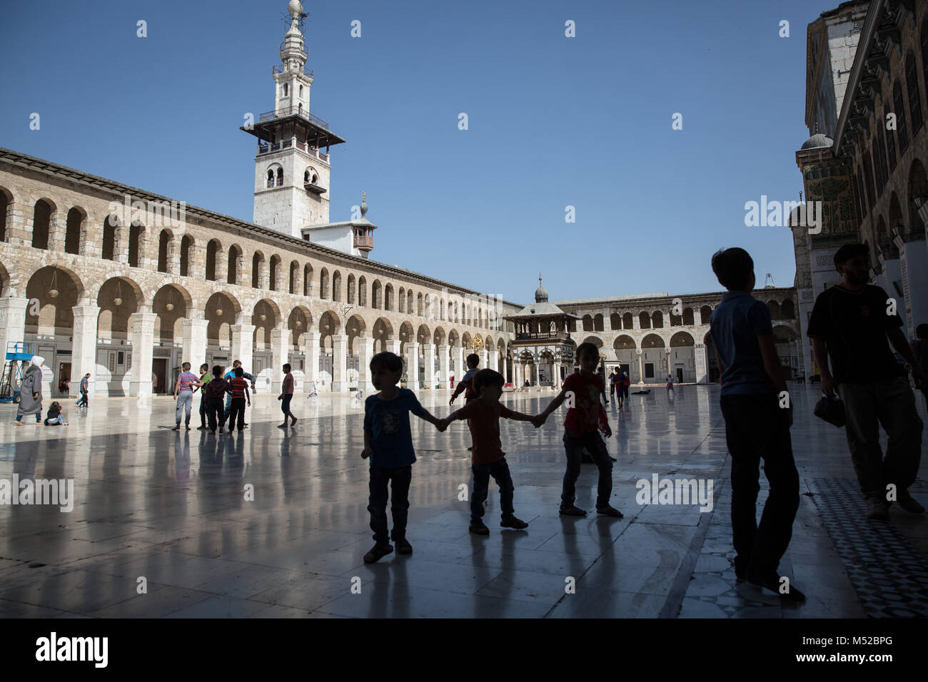 Kinder spielen in Damaskus' Omayyaden-moschee beim Freitagsgebet. Trotz des anhaltenden Konflikts in Syrien, Leben in der Regierung - statt Teile von Damaskus trägt noch auf relativ friedlich. Damaskus, die Hauptstadt von Krieg zerrütteten Syrien, ist meist unter der Kontrolle durch die offizielle syrische Regierung unter der Führung von Präsident Baschar al-Assad. Stockfoto