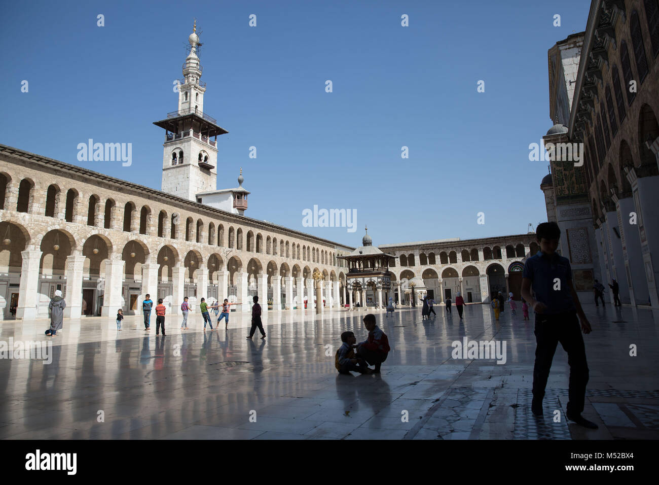 Kinder spielen in Damaskus' Omayyaden-moschee beim Freitagsgebet. Trotz des anhaltenden Konflikts in Syrien, Leben in der Regierung - statt Teile von Damaskus trägt noch auf relativ friedlich. Damaskus, die Hauptstadt von Krieg zerrütteten Syrien, ist meist unter der Kontrolle durch die offizielle syrische Regierung unter der Führung von Präsident Baschar al-Assad. Stockfoto