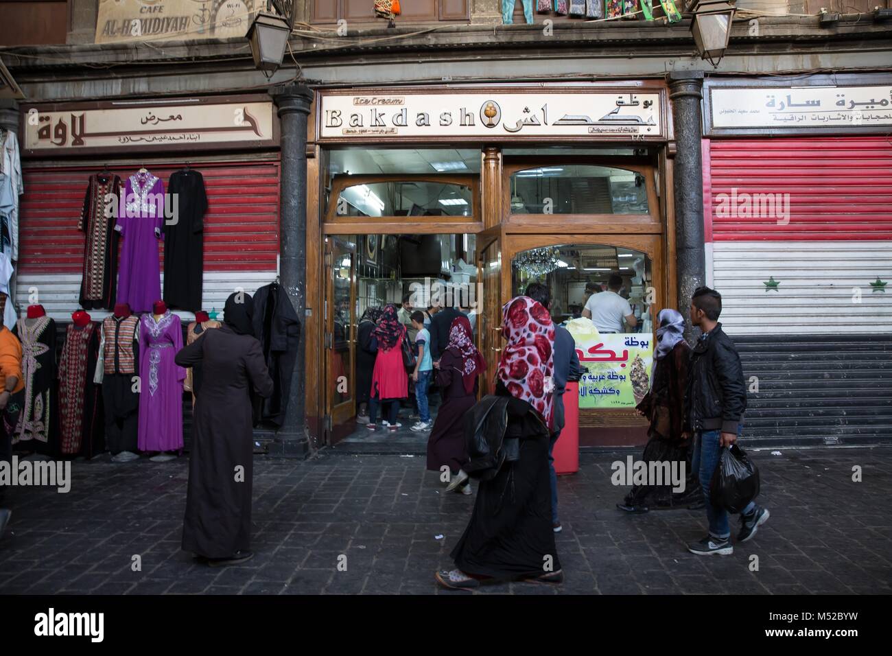 Bakdash, einem berühmten Eisdiele, die in Al-Hamidiyah Souk in der Altstadt von Damaskus seit 1885 geöffnet wurde. Trotz des anhaltenden Konflikts in Syrien, Leben in der Regierung - statt Teile von Damaskus trägt noch auf relativ friedlich. Damaskus, die Hauptstadt von Krieg zerrütteten Syrien, ist meist unter der Kontrolle durch die offizielle syrische Regierung unter der Führung von Präsident Baschar al-Assad. Stockfoto