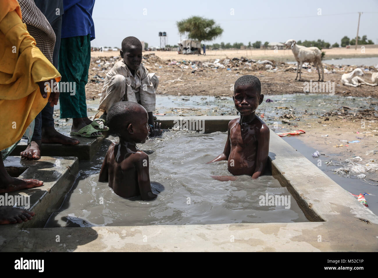 Kinder spielen im Wasser in Muna Garage IDP Camp. Mehr als zwei Millionen wurden während der Konflikt mit Boko Haram verdrängt. Stockfoto