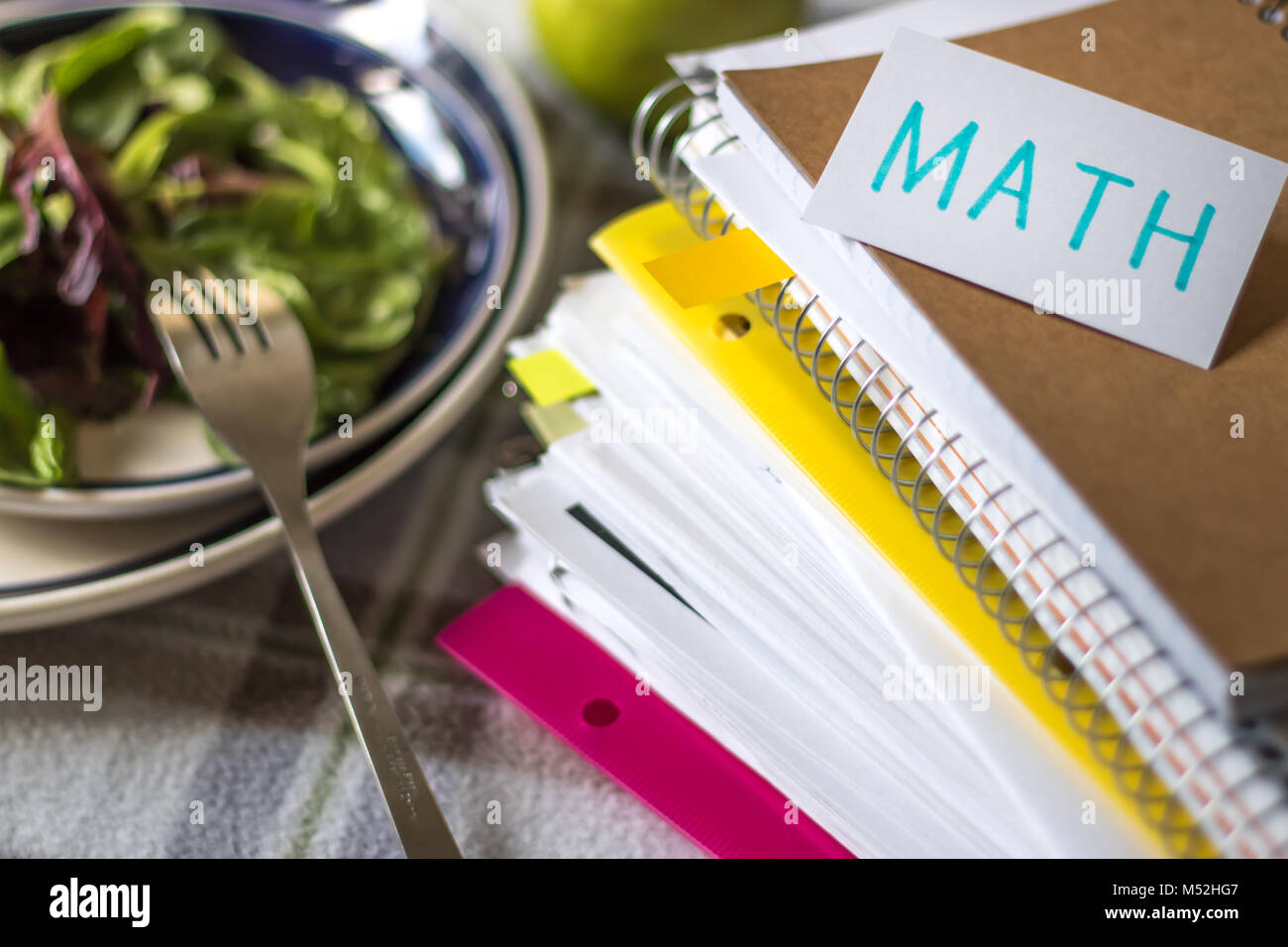 Mathe; Stapel von Dokumenten. Arbeiten oder Studieren während des Essens. Stockfoto