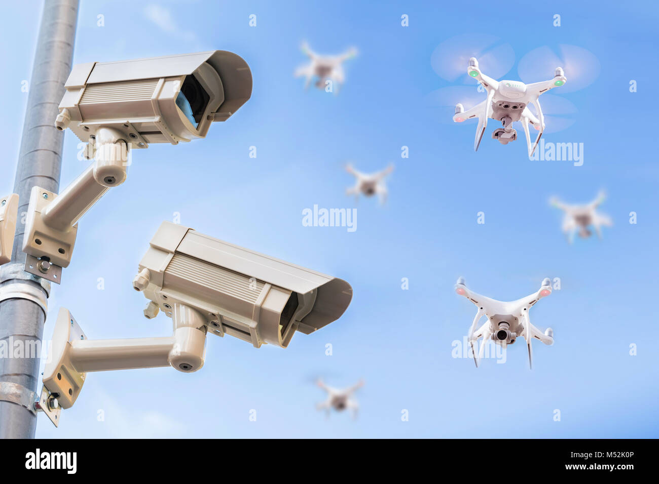 Überwachungskameras auf der Pole mit Drohnen fliegen in den blauen Himmel Stockfoto