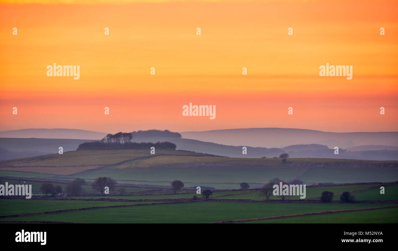 Sonnenuntergang über Minning niedrigen Hügel historischen England Monument mit einem chambered Grab & zwei Schüssel schubkarren von Harborough Felsen, Peak District, UK gesehen Stockfoto