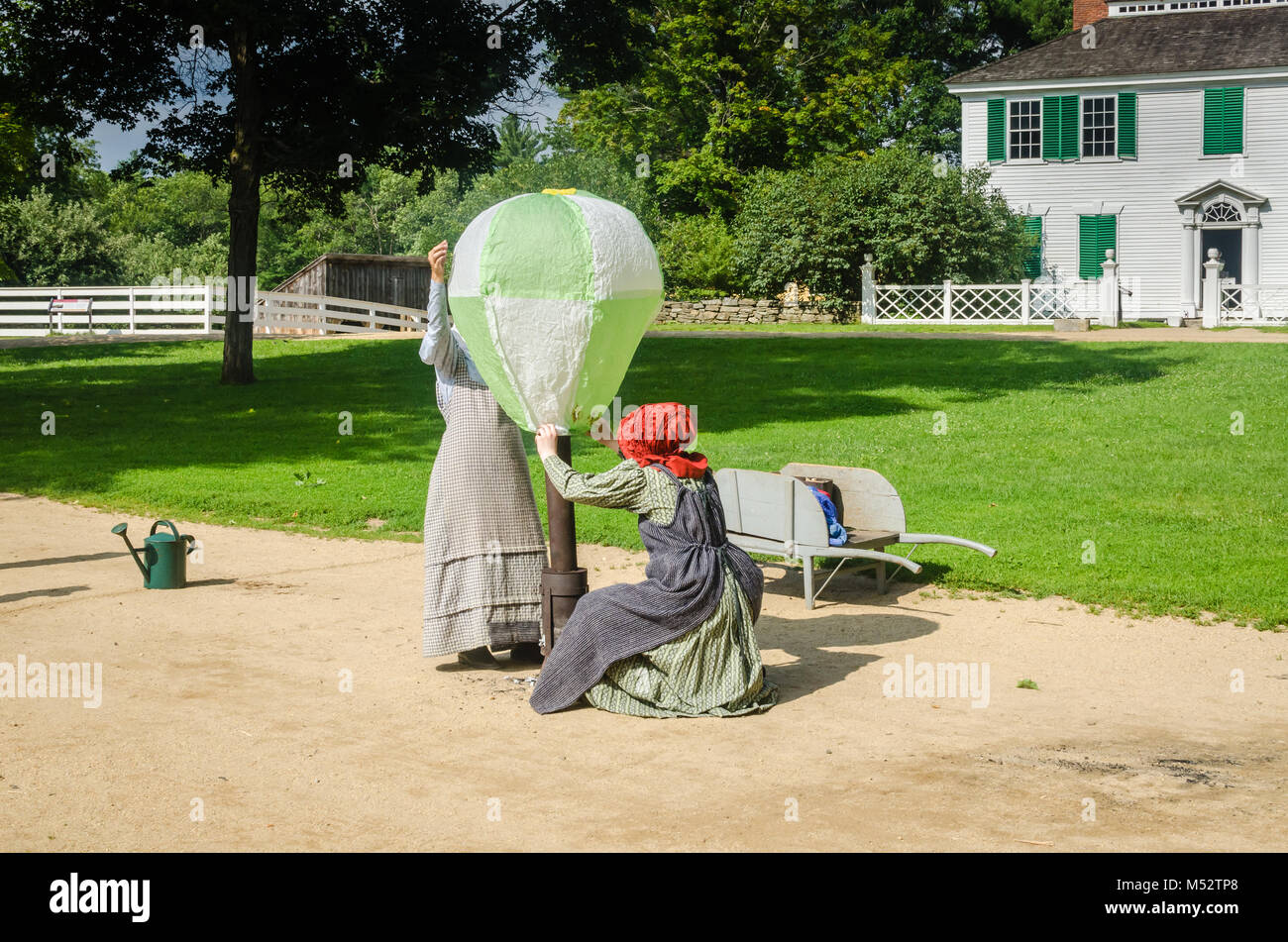 Zwei Frauen, die in historischen Kostümen an Old Sturbridge Village, füllen ein hausgemachtes Heißluftballon in antikem Spielzeug Demonstration. Stockfoto