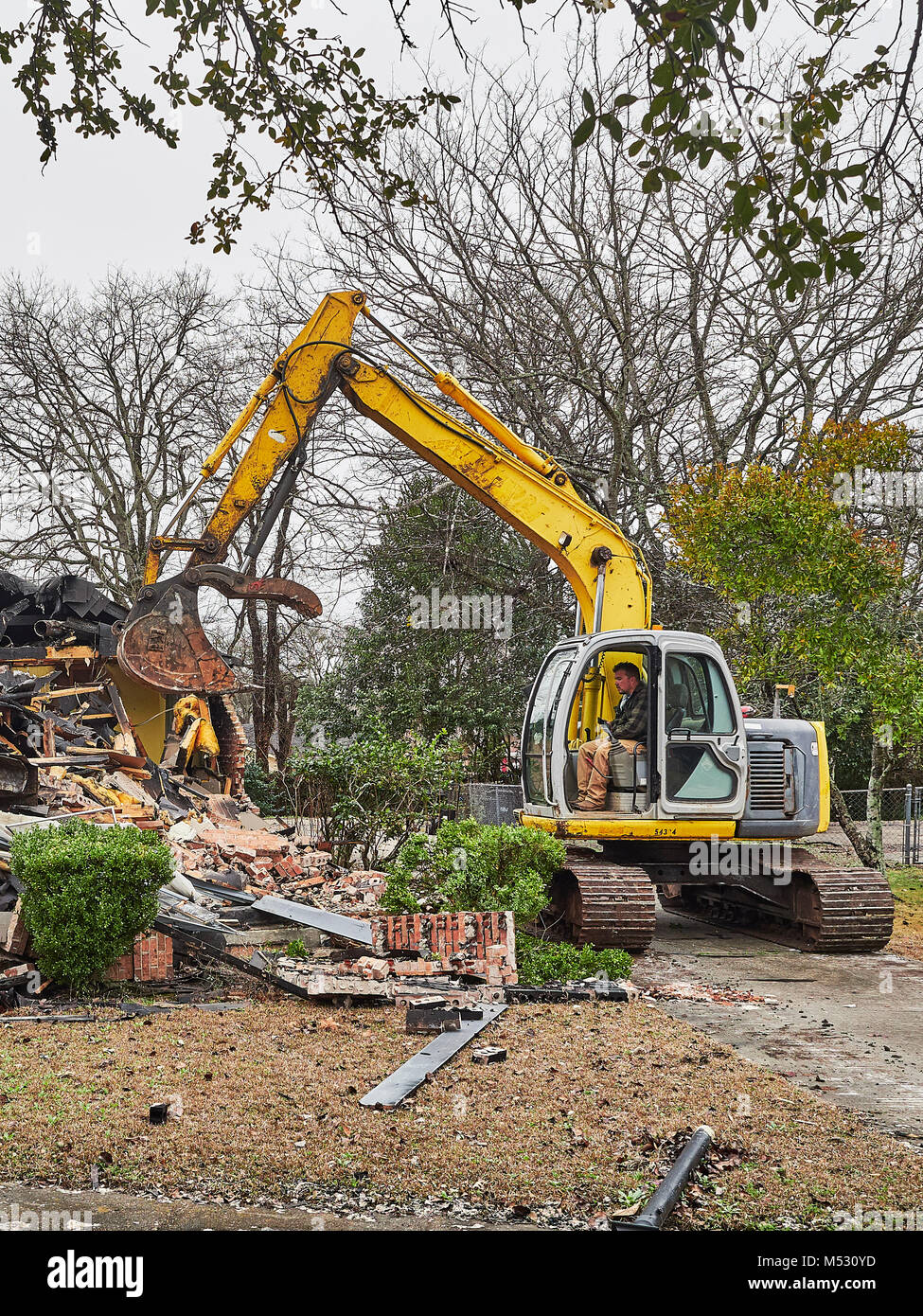 Arbeitnehmer mit schweren Bagger zu helfen, ein Haus, das Feuer gefangen und in Montgomery Alabama, USA verbrannt demolieren. Stockfoto