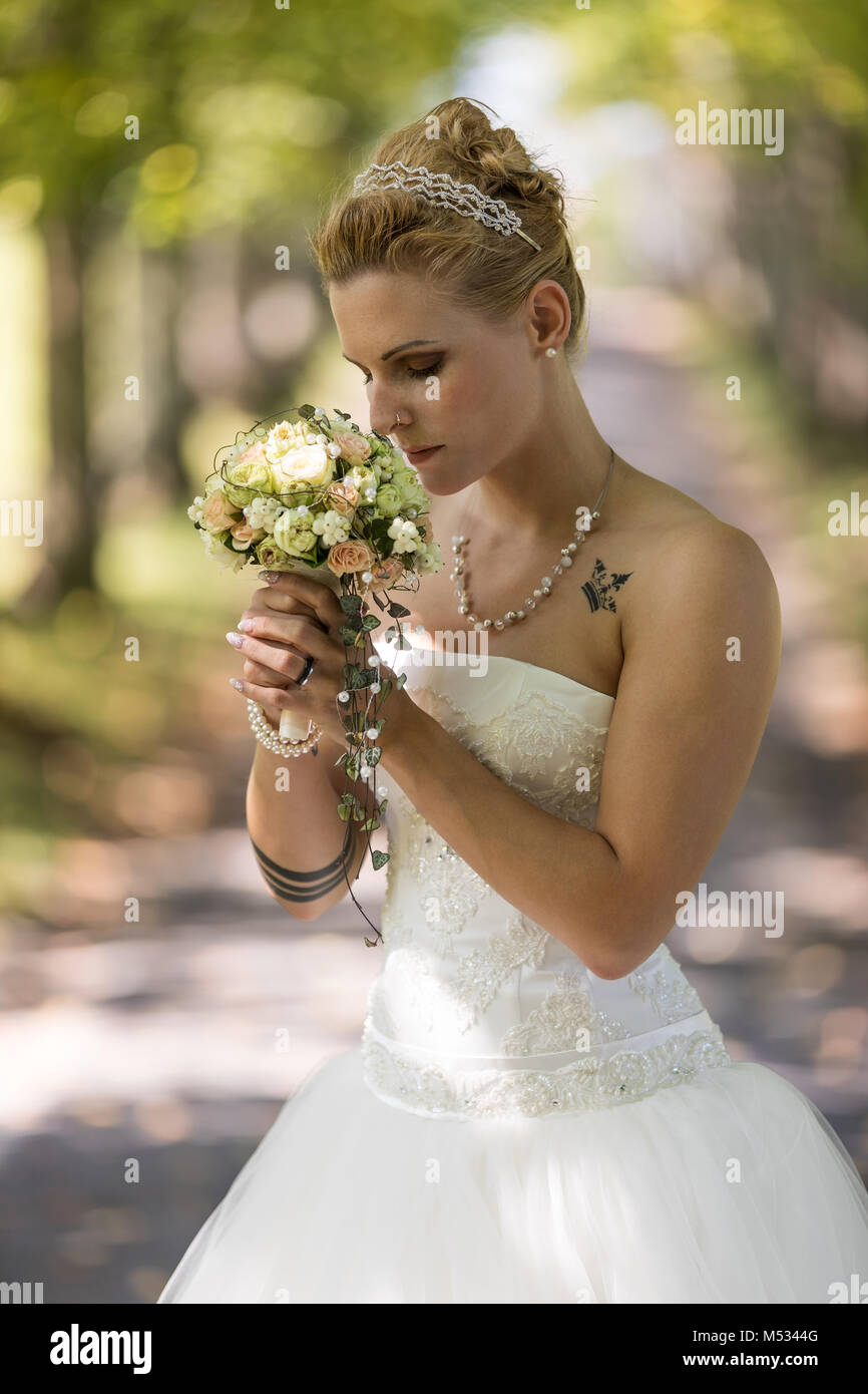 Junge blonde Frau im weißen Brautkleid Stockfoto