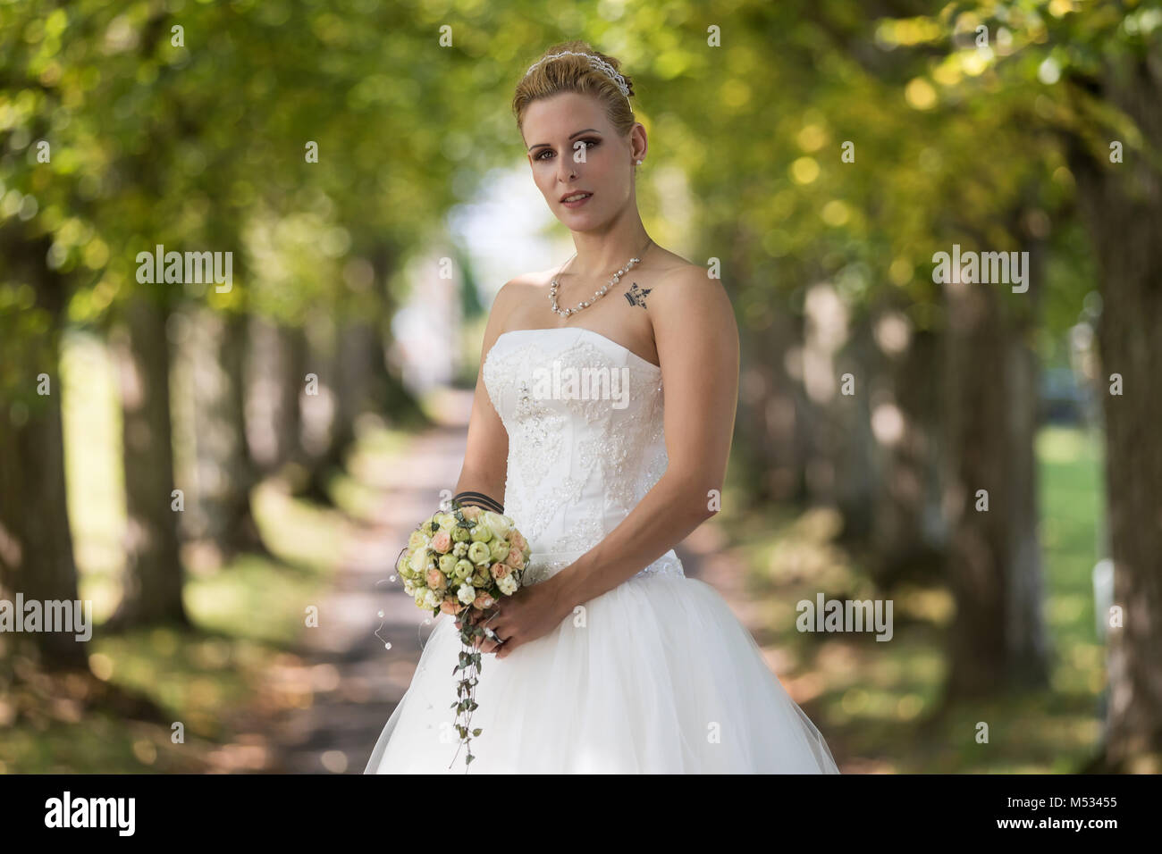 Junge blonde Frau im weißen Brautkleid Stockfoto