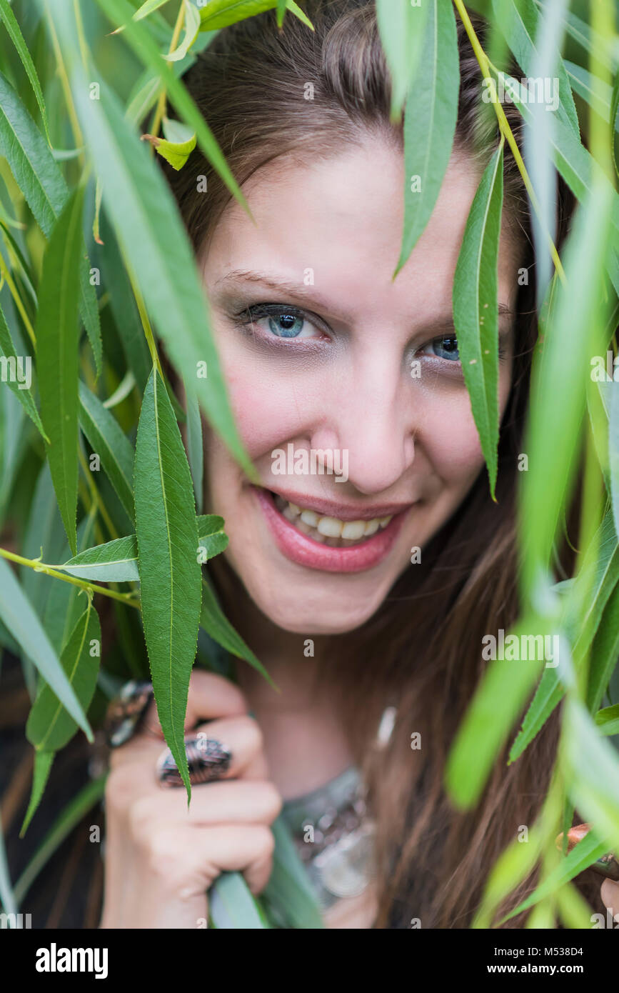 Gerne fröhliche Frau mit Efeu bedeckt Stockfoto