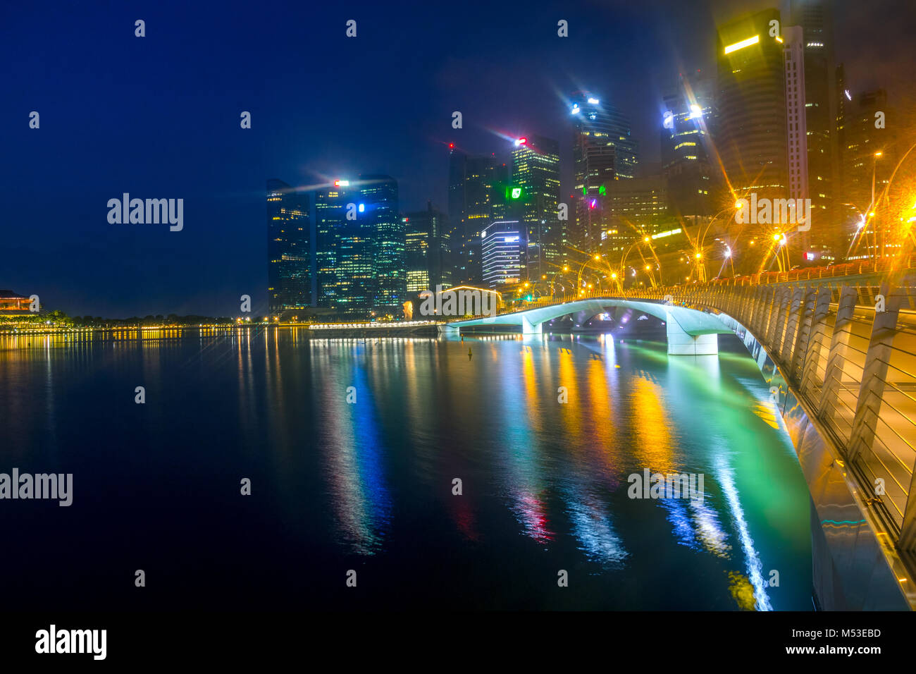 Singapore Downtown befindet sich in einem leichten Nebel. Nacht Marina Bay. Fußgängerzone Esplanade Bridge, schlafen Merlion und Wolkenkratzer Stockfoto