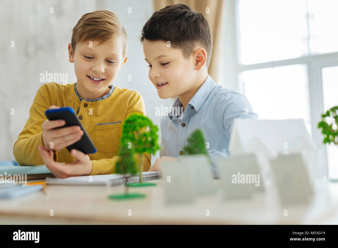 Fröhlichen jungen auf der Suche nach Ideen für ihre Ökologie Projekt Stockfoto