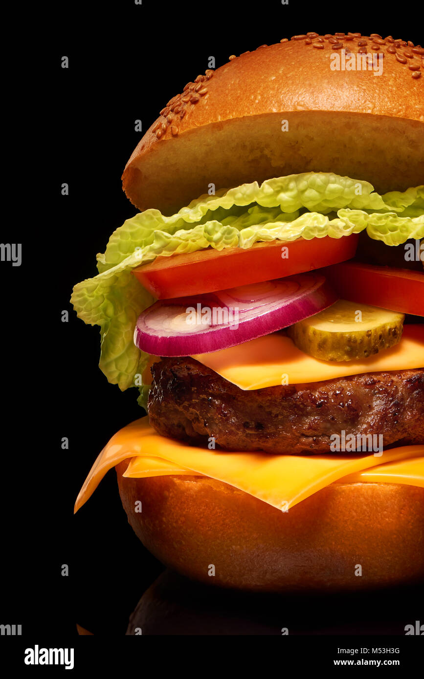 Clouse, leckere Hamburger mit Käse, Gurken, Tomaten, Zwiebeln und Salat auf schwarzen Hintergrund mit Reflektion Stockfoto