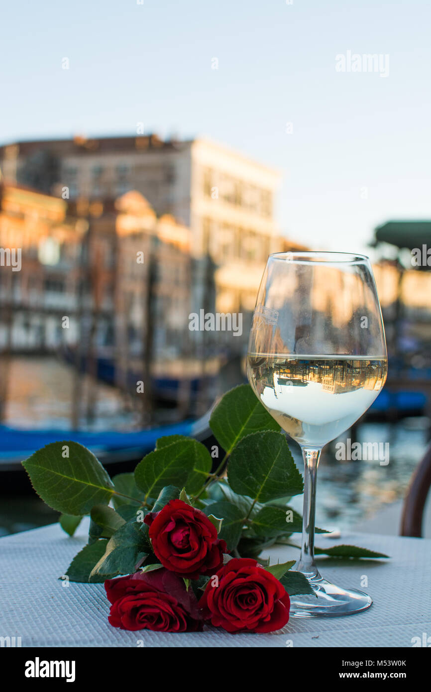 Trinken Weißwein auf ein Datum mit roten Rosen und eine Mahlzeit auf dem Canale Grande, Venedig, Italien Stockfoto