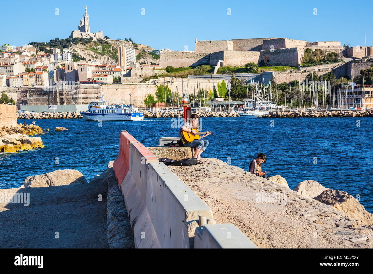 Mädchen, die auf der Gitarre am Meer Pier Stockfoto