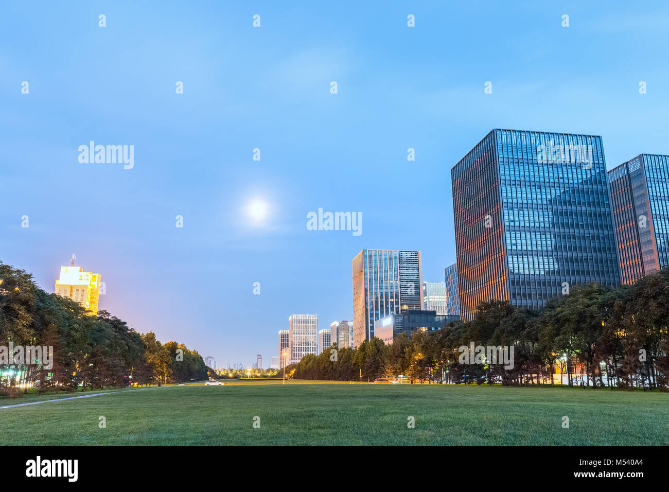 Moderne Gebäude mit grünen Raum in Nightfall Stockfoto