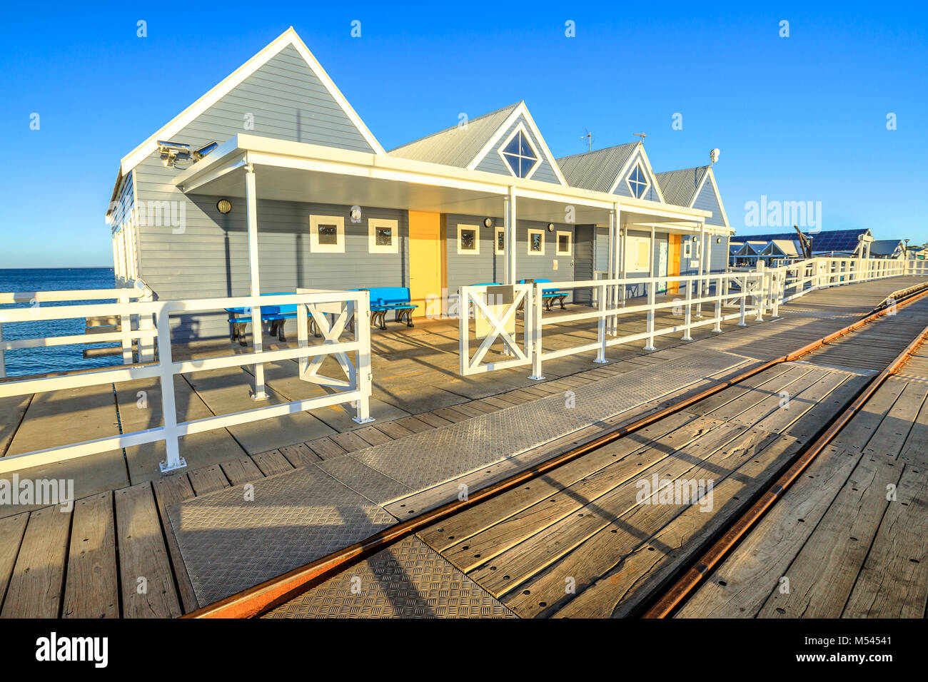 Spuren der Bahn auf Busselton Jetty in Busselton, Western Australia. Die Anlegestelle ist die längste hölzerne Struktur in der südlichen Hemisphäre. Berühmte Ort. Saison Sommer, blauer Himmel. Stockfoto