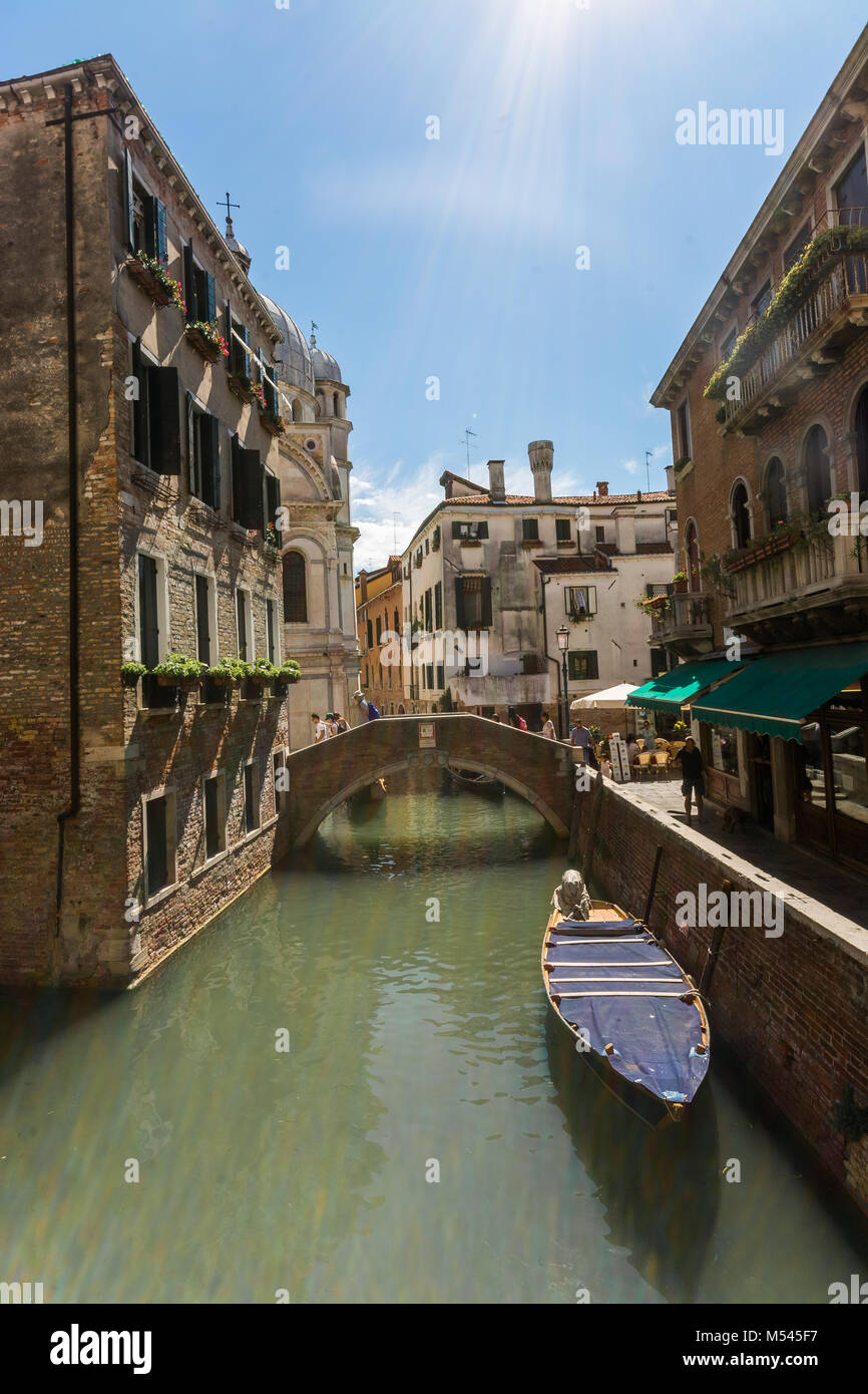 Die wunderschönen Venezianer Stadt Kanal Routen und Gondelfahrten, die Sun Flair in der Ecke der Altstadt Gebäude vor. Stockfoto
