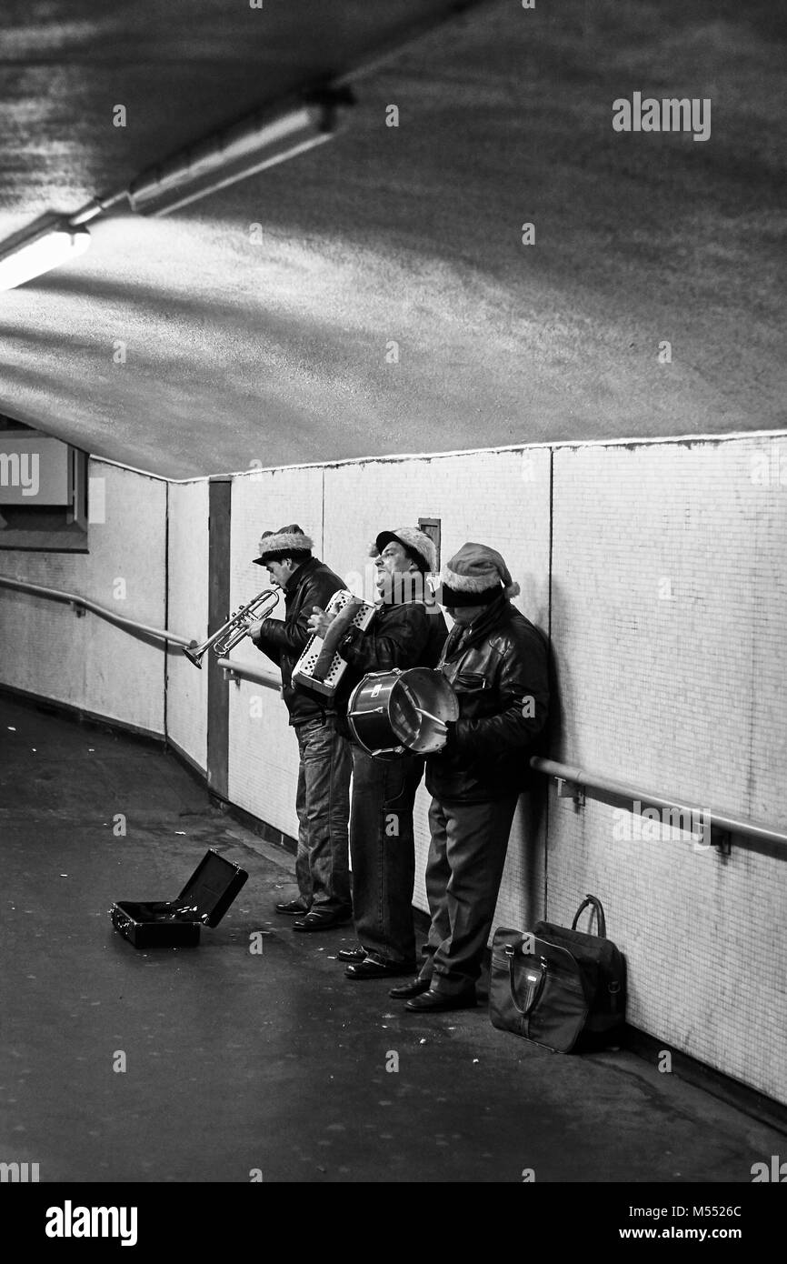 Ein Band der drei Straßenmusiker in einen unterirdischen Gang in London England spielen Stockfoto