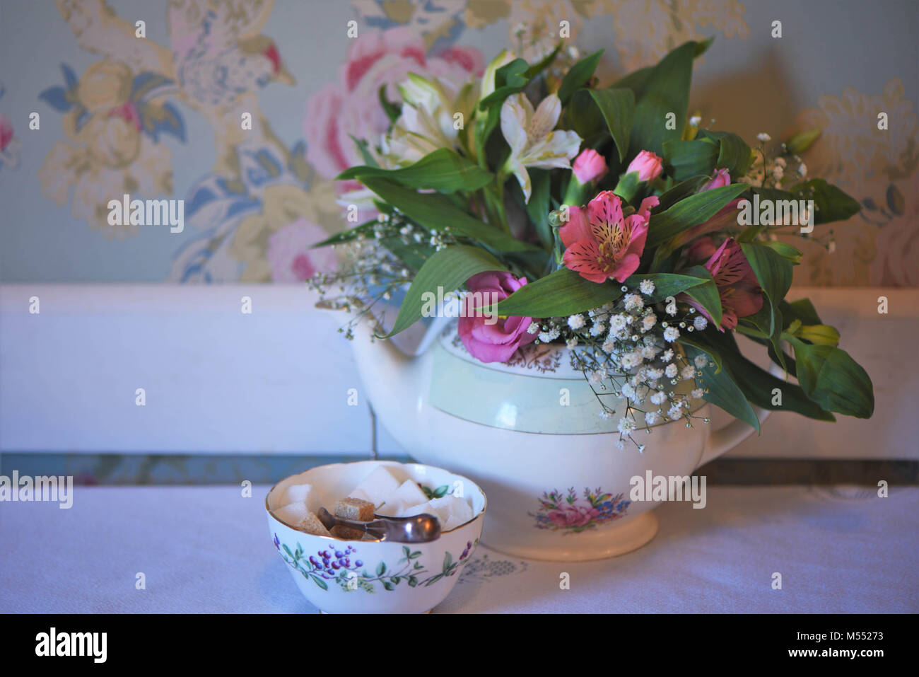 Vintage Teekanne und Sugar Bowl auf einem Tisch mit frischen Blumen gefüllt Stockfoto