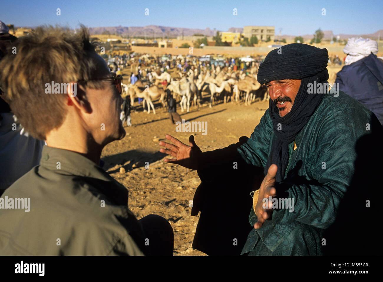 Algerien. Tamanrasset. Sahara. Kamel Markt. Camel-Driver und touristische, Frau. Stockfoto