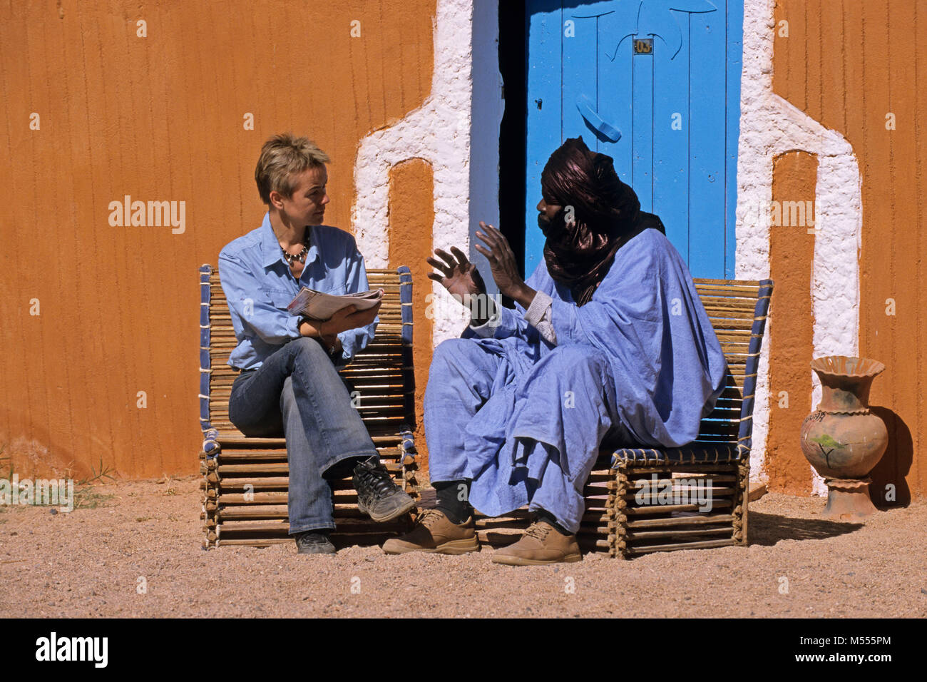 Algerien. Tamanrasset. Sahara. Mann der Tuareg Stamm und touristische, Frau sprechen. Stockfoto