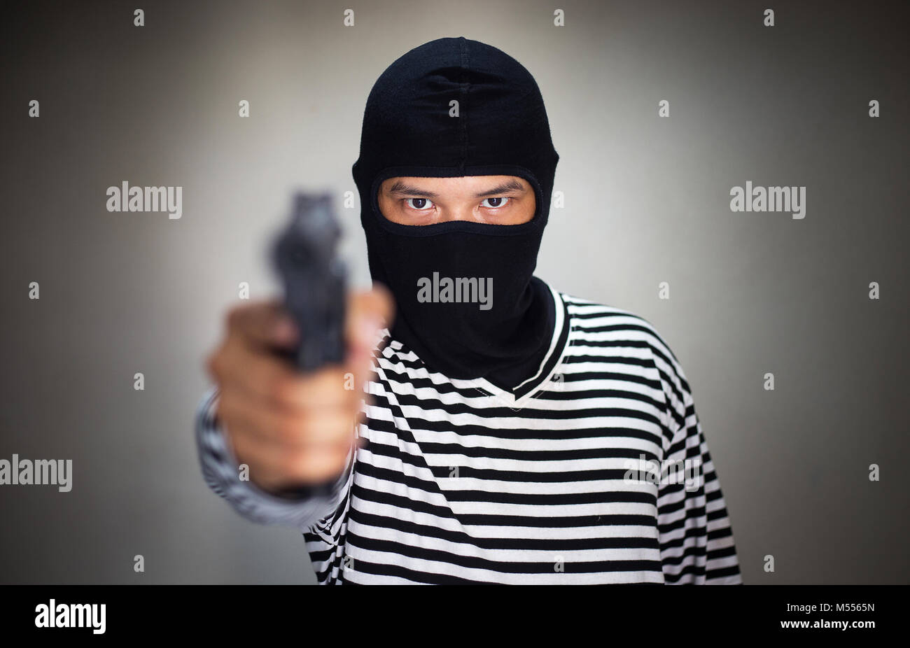 Terroristische ware Maske und halten Sie die Pistole, Gewehr, in der Hand für Rob Asset oder ein Verbrechen machen Stockfoto