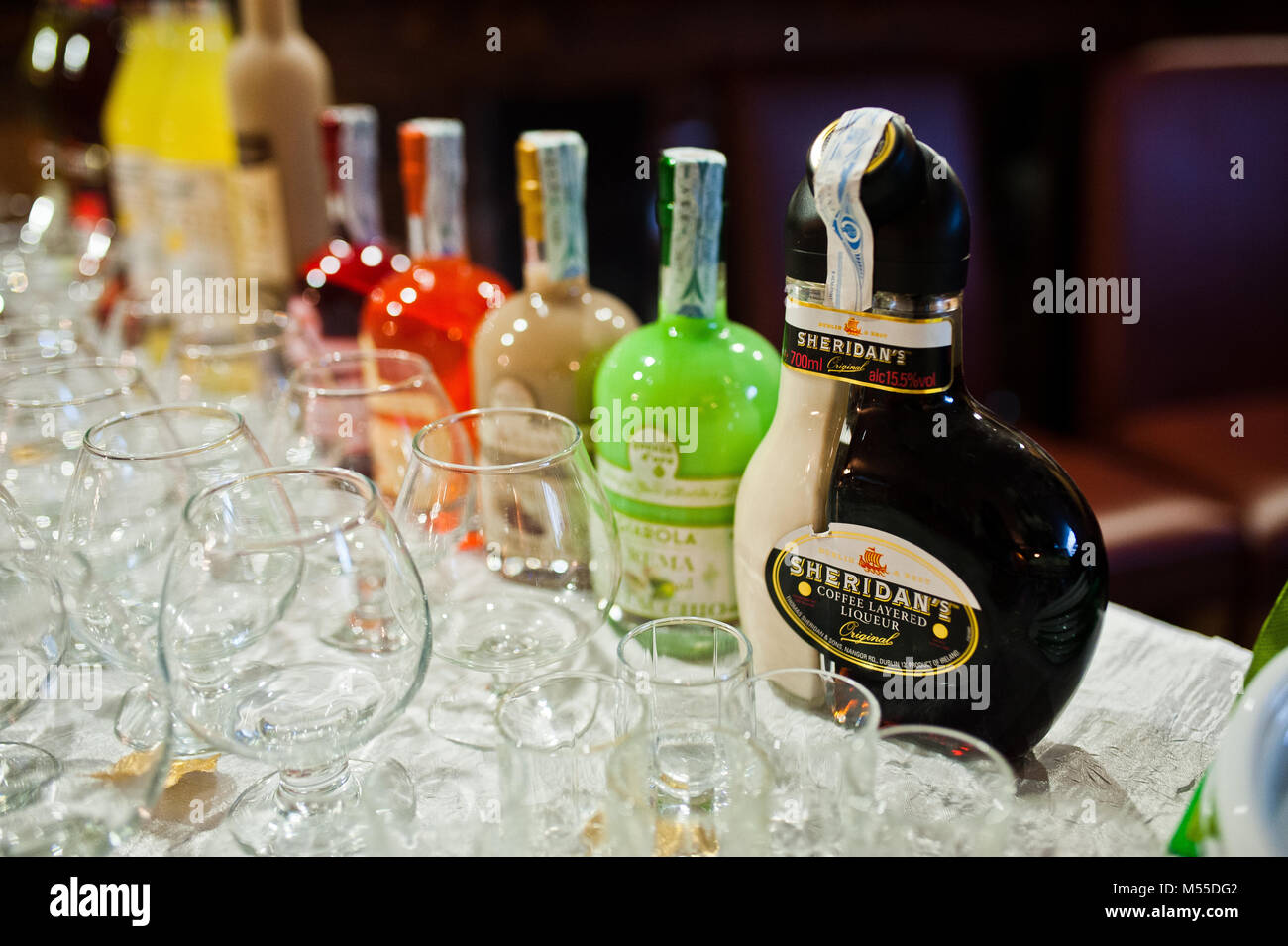 Hai, der Ukraine - 08. Februar 2018: Sheridan's Coffee Likör und andere  alkoholische Getränke in Flaschen auf dem Tisch zusammen mit leeren  Weingläsern Stockfotografie - Alamy