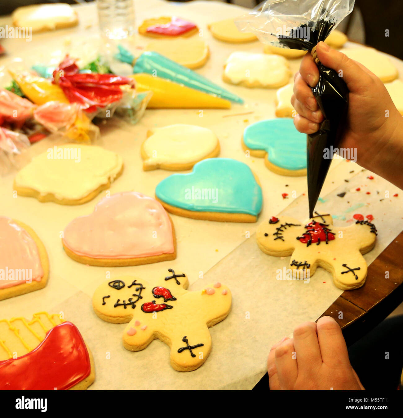 Davenport, Iowa, USA. 11 Feb, 2018. Sarah Henderson von Davenport Rohre Vereisung durch einen Beutel auf ihre anti-Valentines Tag cookie, Sonntag, Februar 11, 2018, während ein Cookie Dekoration Klasse gehalten im Oh So süß von Tiphanie bei 314 Main St. in Davenport befindet. Quelle: John Schultz/Viererkabel - Zeiten/ZUMA Draht/Alamy leben Nachrichten Stockfoto