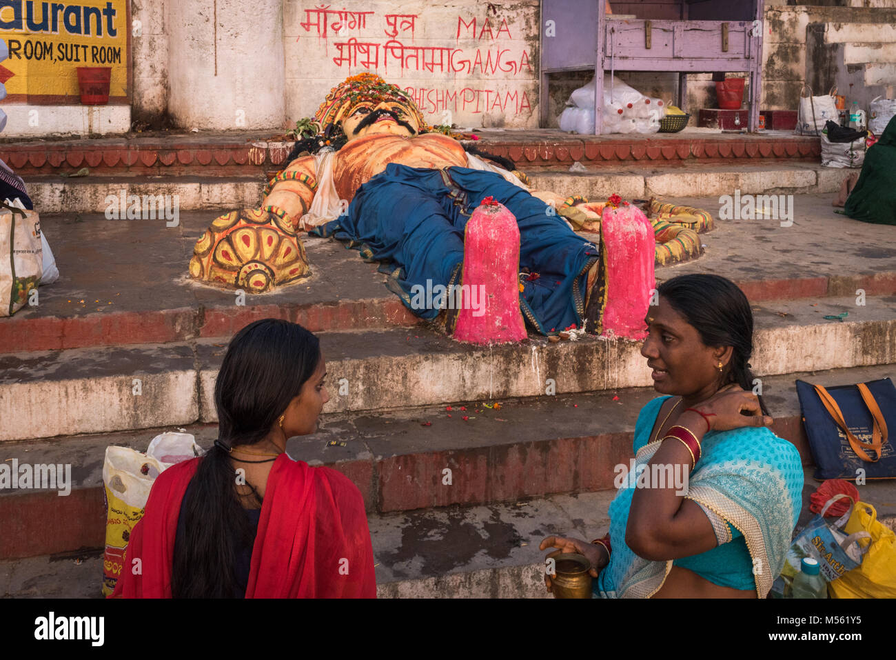 Frauen durch einen Gips hinduistischen Gottheit am Ufer des Ganges, Varanasi, Indien chatten Stockfoto