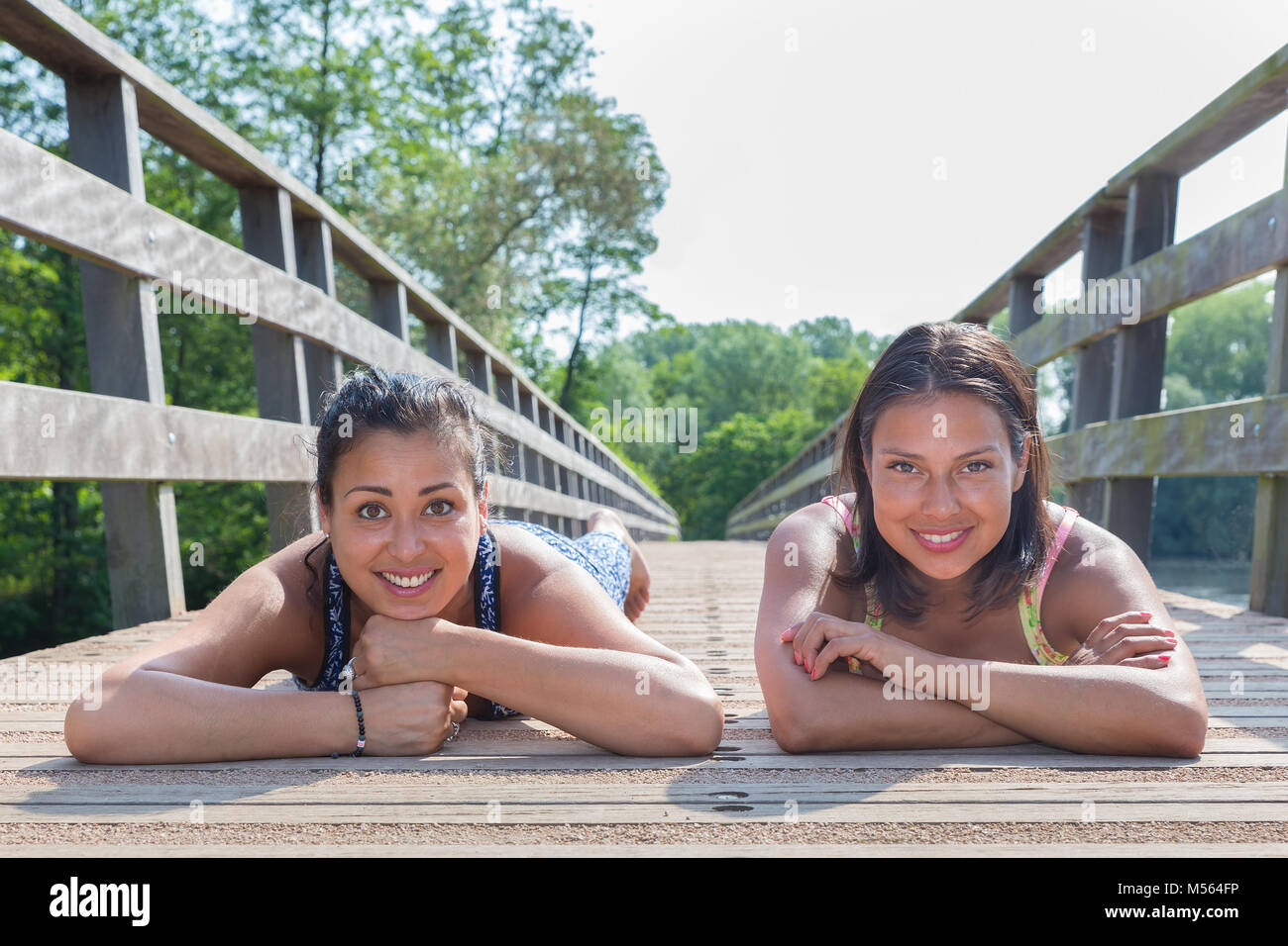 Zwei Freunde, die zusammen liegen auf Holzbrücke Stockfoto