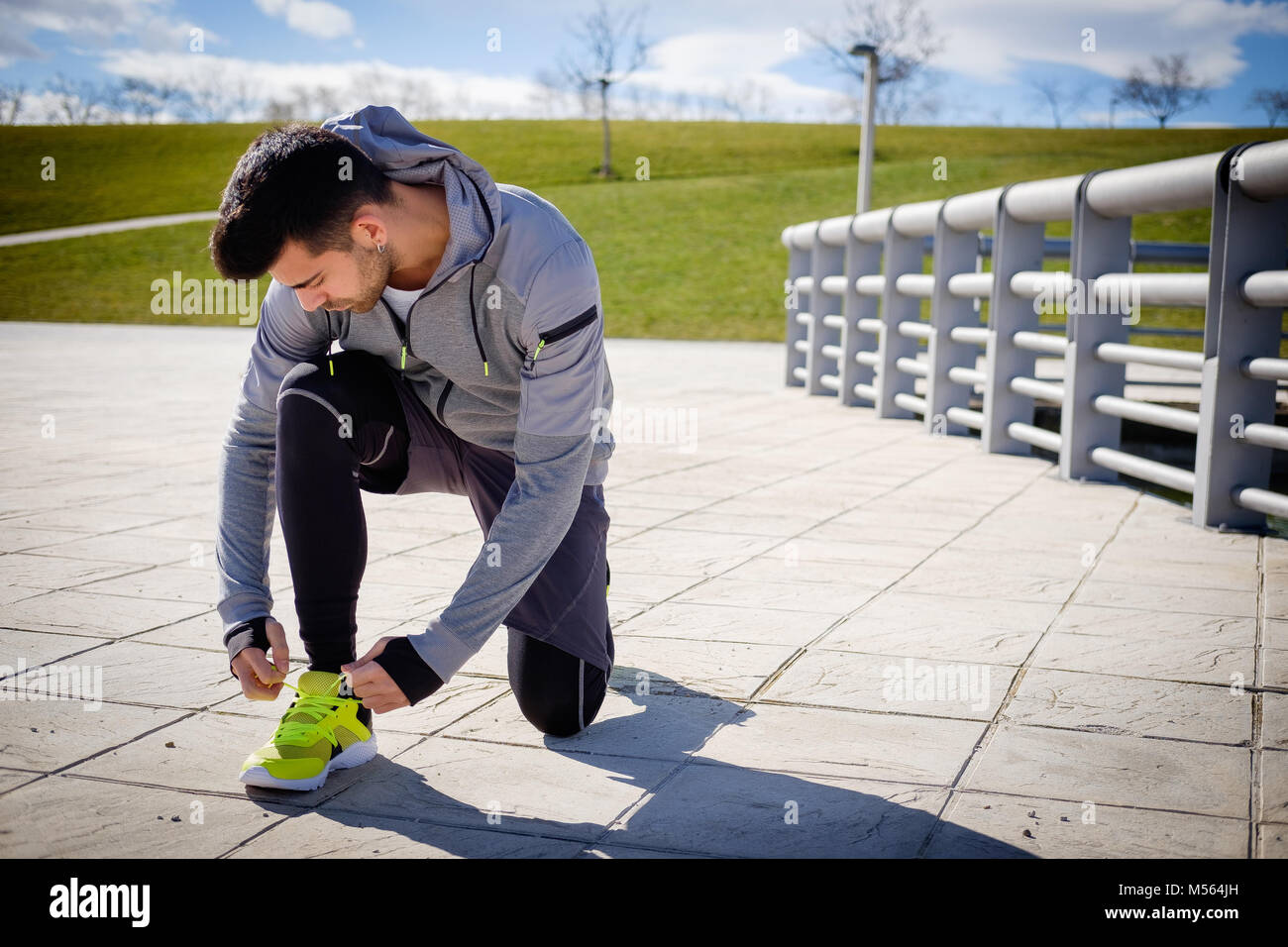 Einen jungen kaukasischen athletischen Mann bereitet sich vor der Ausführung in einer Stadt Park im Winter. Stockfoto