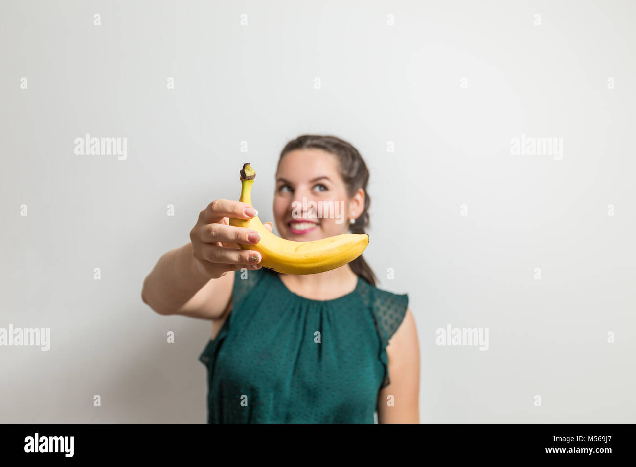 Pretty Woman streckt die Banane Obst Stockfoto