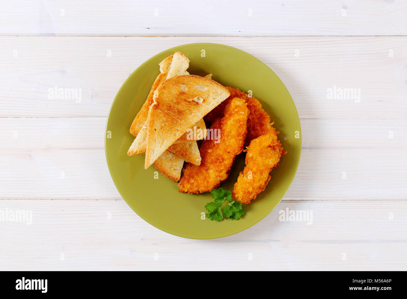 Hähnchen Schnitzel mit Toast auf der grünen Platte Stockfoto